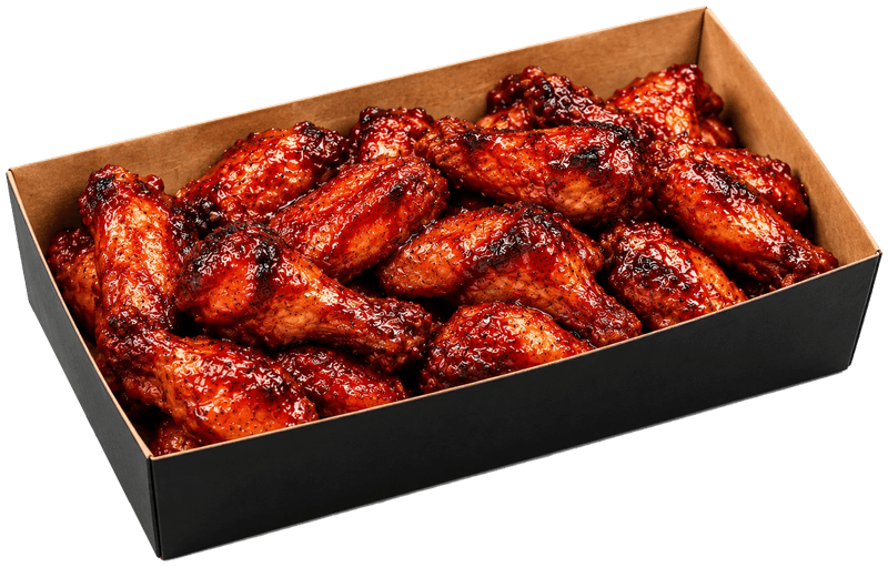 Glazed grilled chicken wings in a black tray