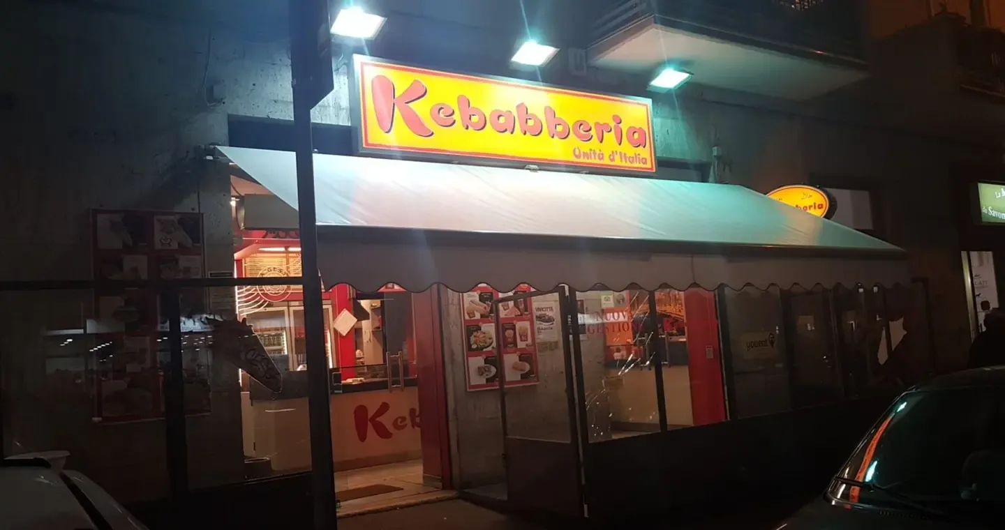 The storefront of Kebabberia Bari – Unità d’Italia in the evening, with the sign lit