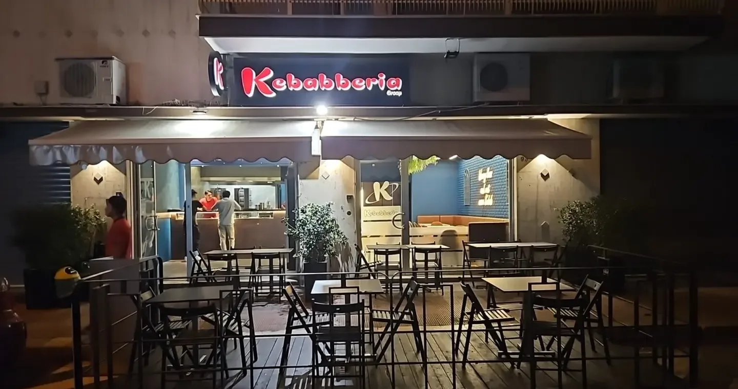 The terrace of Kebabberia Bari – Campus in the evening, with tables and the open kitchen